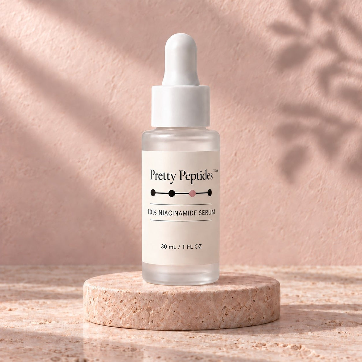 Pretty Peptides 10% Niacinamide Serum, 30 ml frosted dropper bottle on a travertine riser against a blush plaster wall