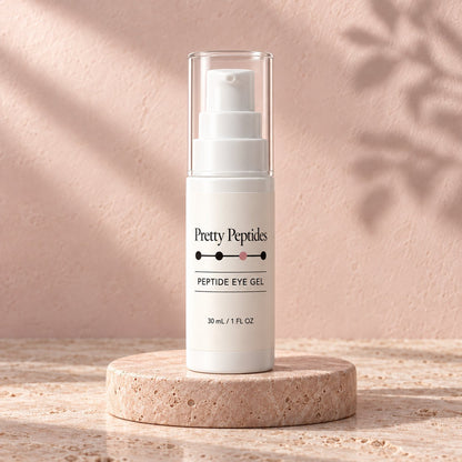 Pretty Peptides Peptide Eye Gel, 30 ml pump bottle on a travertine riser against a blush plaster wall