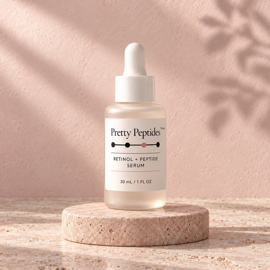 Pretty Peptides Retinol + Peptide Serum, 30 ml frosted dropper bottle on a travertine riser against a blush plaster wall