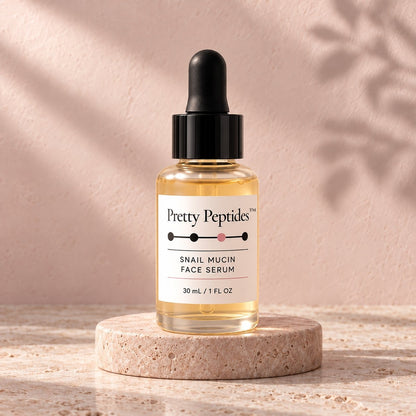 Pretty Peptides Snail Mucin Face Serum, 30 ml dropper bottle on a travertine riser against a blush plaster wall